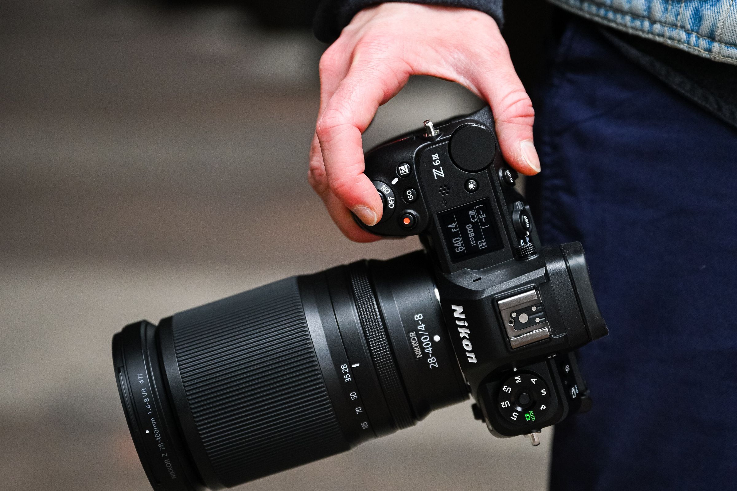 Hand at a person’s side holding a camera