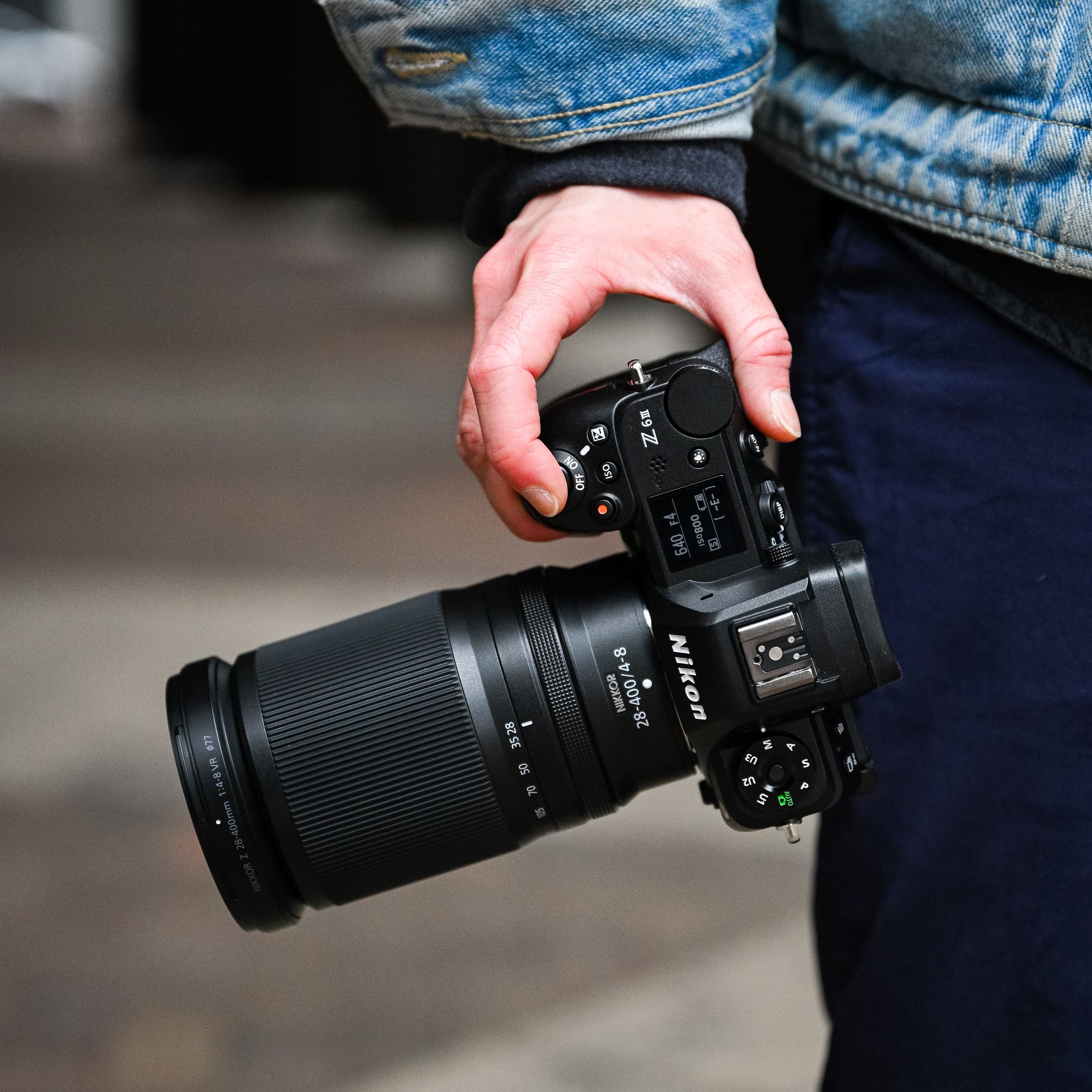 Hand at a person’s side holding a camera