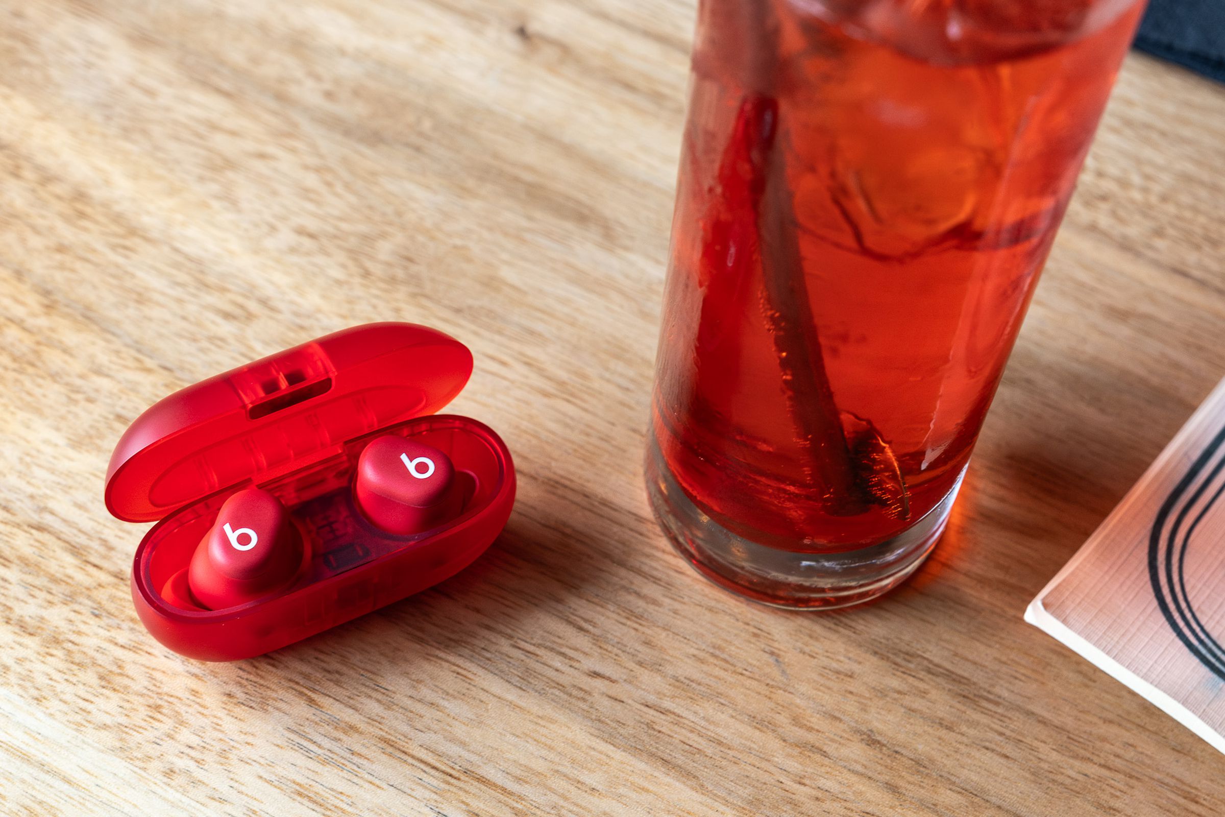 A photo of the Beats Solo Buds next to a cocktail drink.