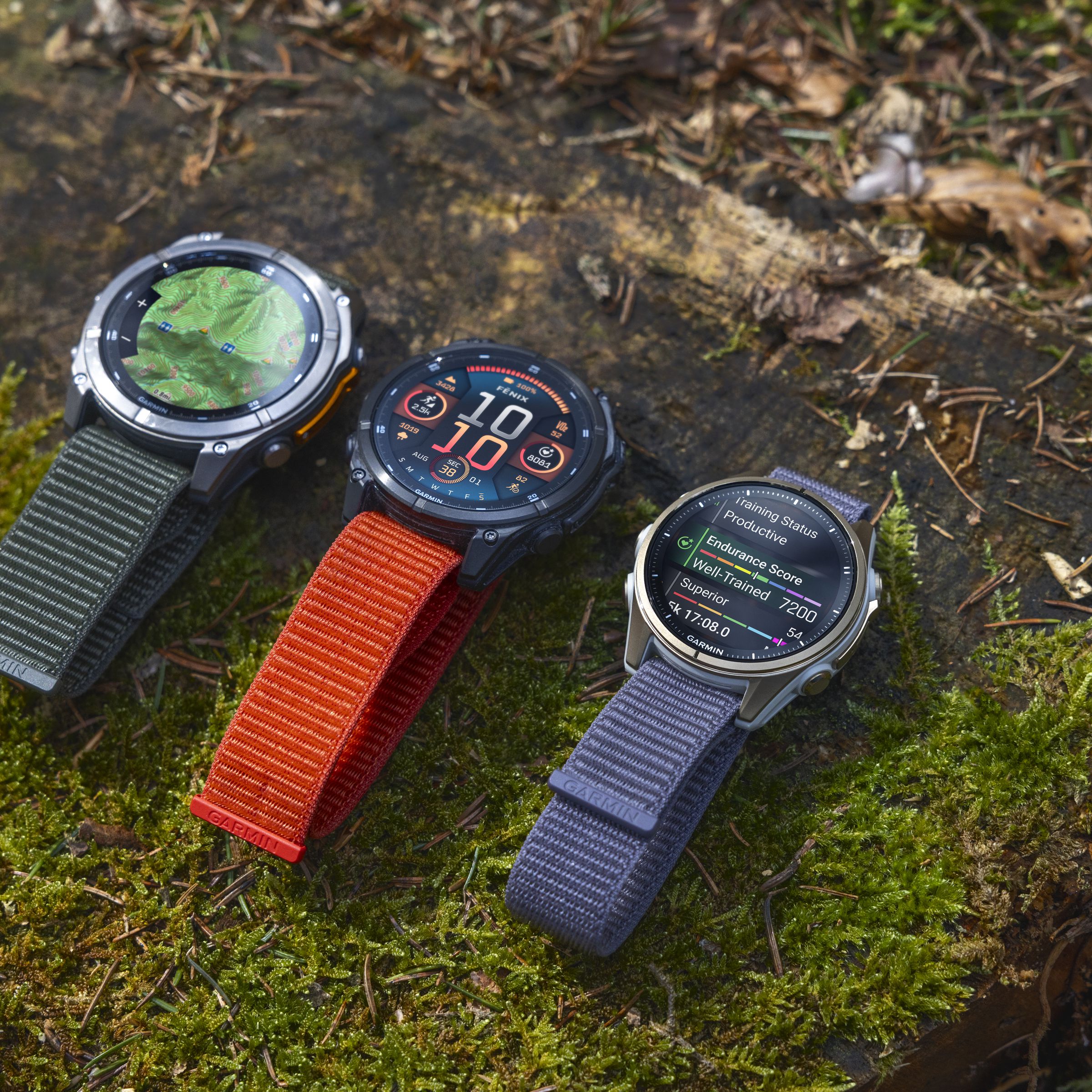 Three of the Garmin Fenix 8 models side by side on grass