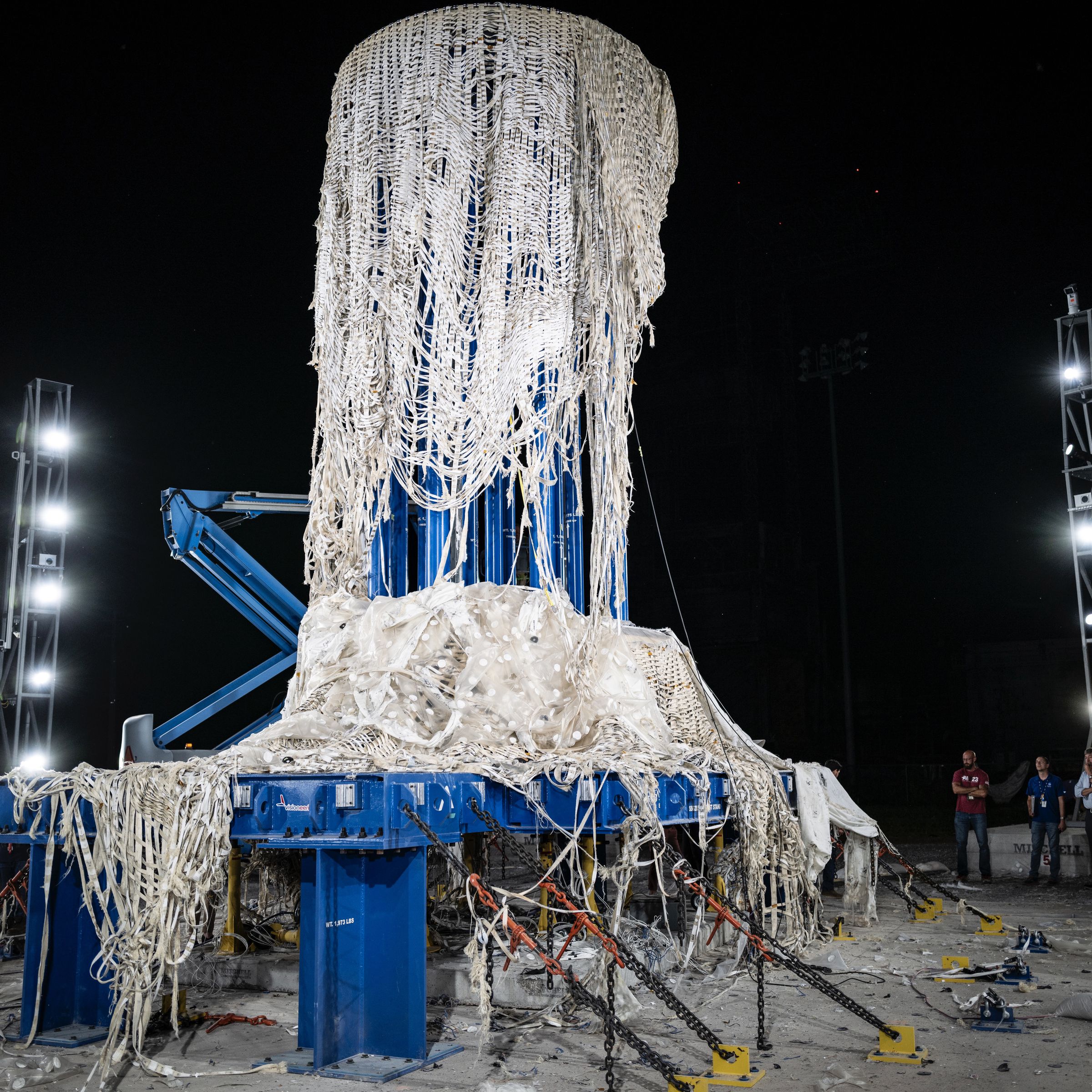 bursted LIFE structure, fabric weave is hanging from a blue platform